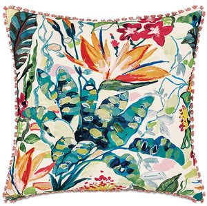 A square decorative throw pillow featuring a vibrant, painterly tropical floral pattern with green, teal, orange, and red botanical elements on an off-white background, finished with a fringed border.